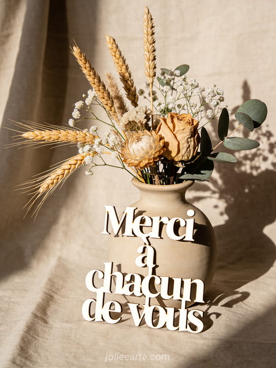Composition de fleurs séchées dans un vase en grès avec épis de blé et le texte Merci à chacun de vous