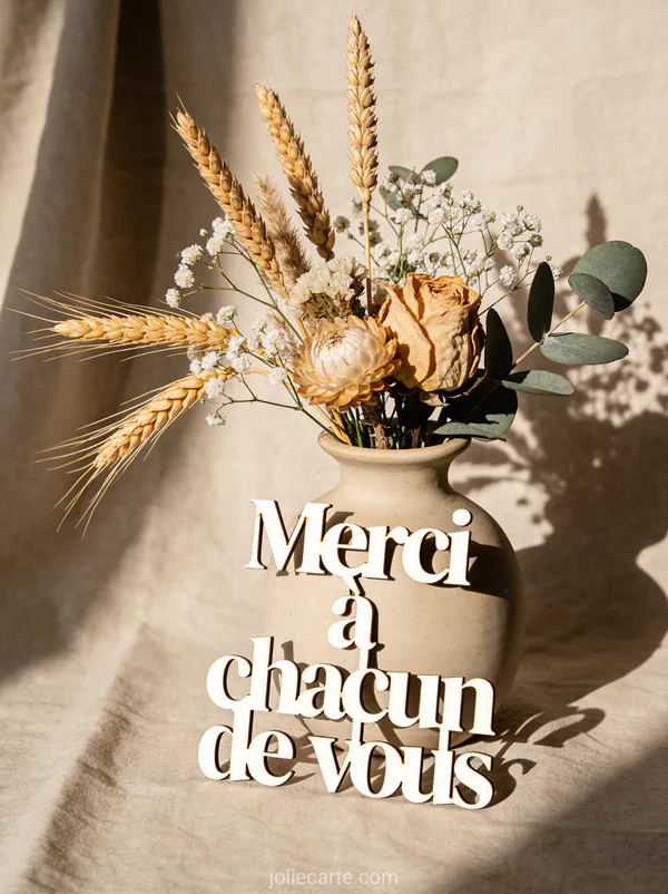 Composition de fleurs séchées dans un vase en grès avec épis de blé et le texte Merci à chacun de vous