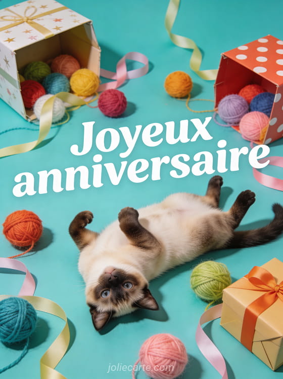 Texte Joyeux anniversaire en lettres blanches sur fond turquoise avec chat siamois joueur parmi des pelotes de laine colorées et boîtes cadeaux