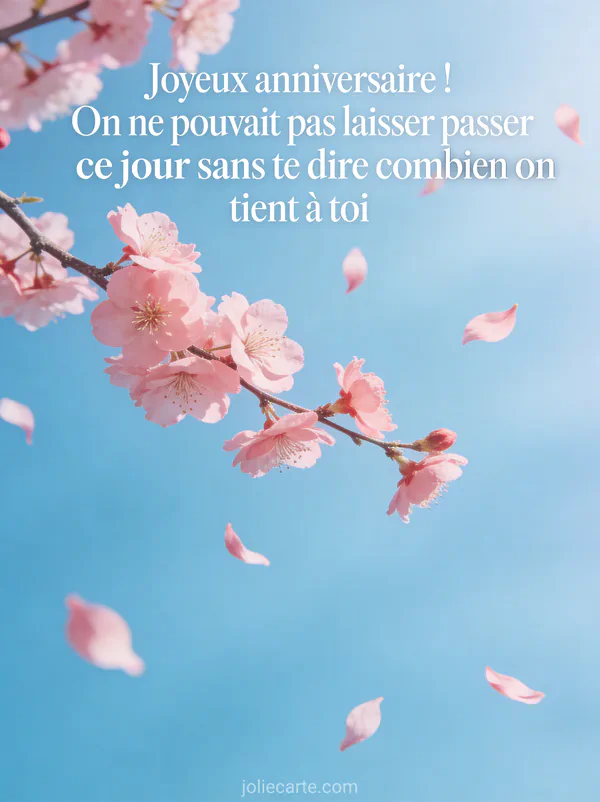 Branche de cerisier en fleurs avec pétales roses qui s'envolent sur fond bleu pastel et texte joyeux anniversaire en typographie blanche