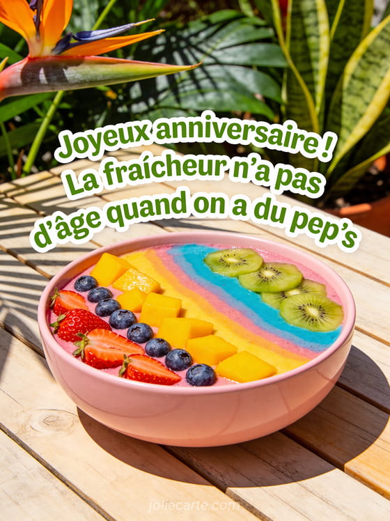 Smoothie bowl géant coloré avec fruits frais disposés en arc-en-ciel dans un bol en céramique rose sur une table en bois