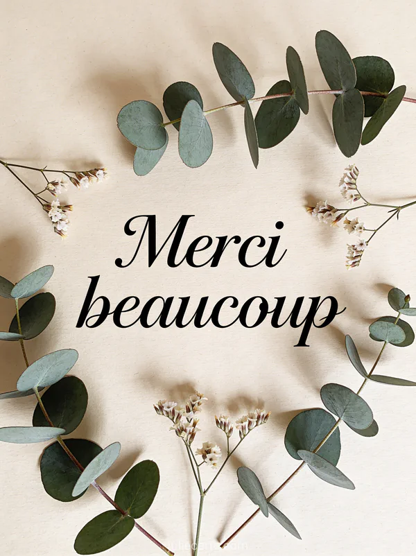 Texte Merci beaucoup en calligraphie noire sur papier crème entouré de branches d'eucalyptus et de petites fleurs séchées style minimaliste