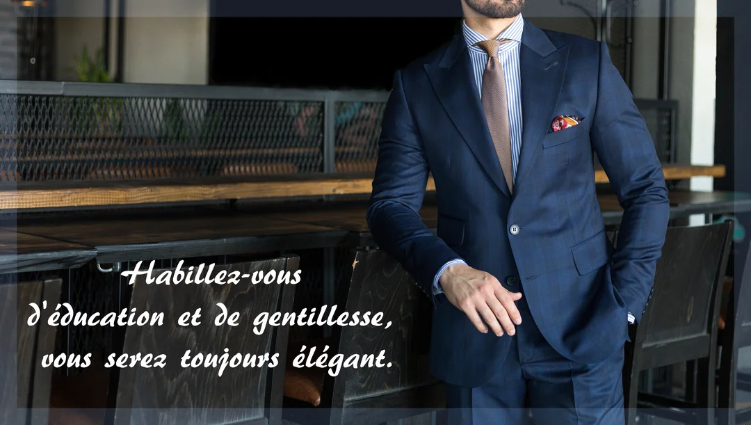 Un homme non identifiable, de torse, porte un élégant costume bleu, une chemise rayée et une cravate, posant dans un décor sobre.