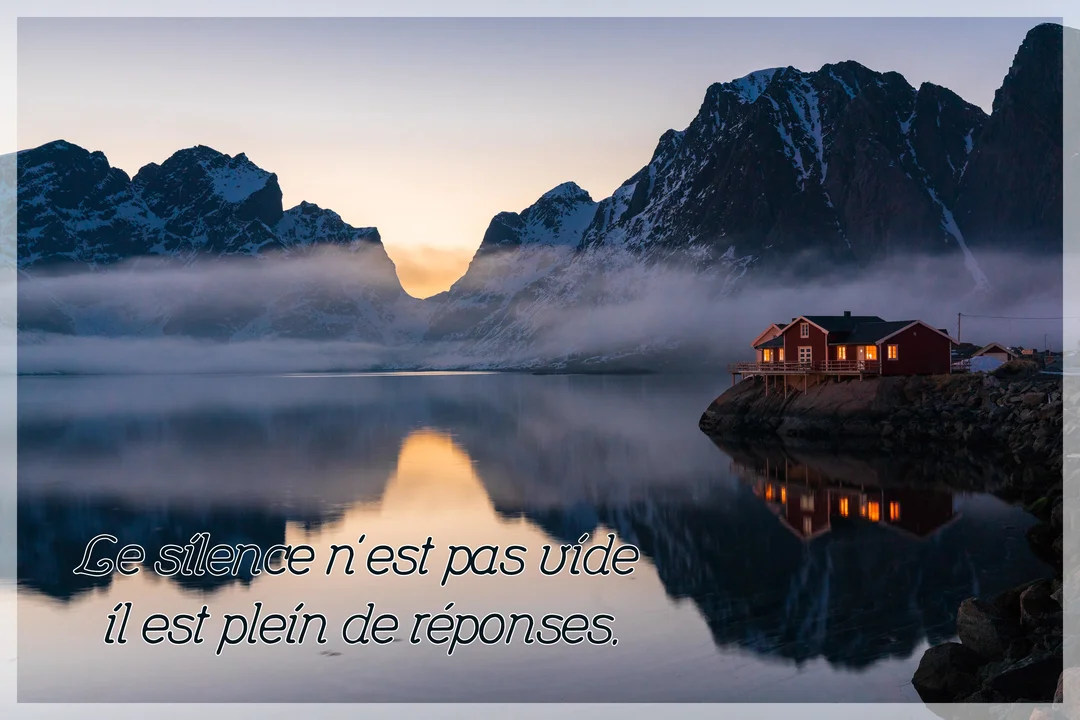 Une maison rouge illuminée se dresse au bord d'un lac calme, reflétant des montagnes enneigées sous un ciel de crépuscule brumeux.