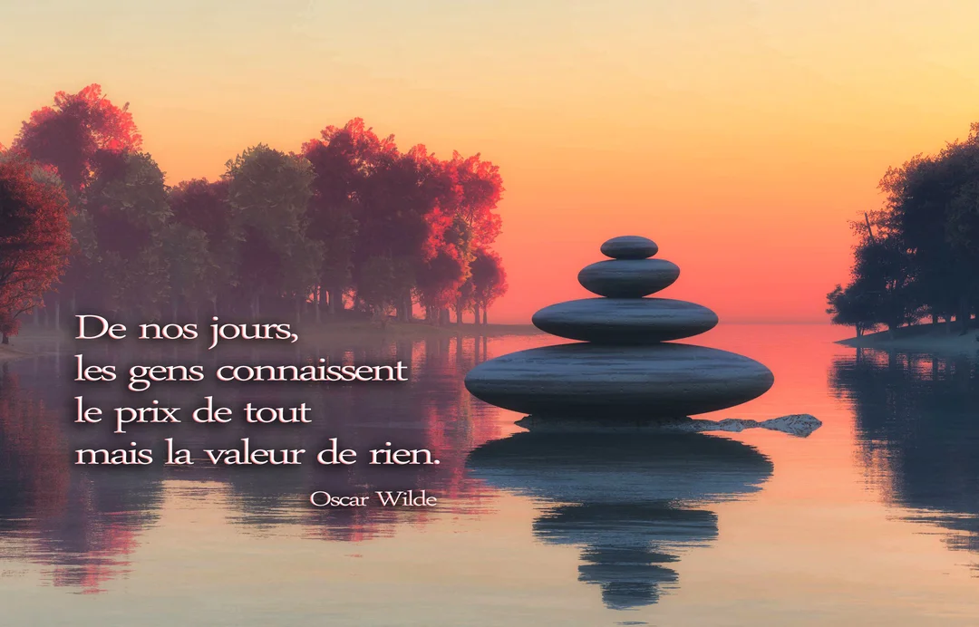 Des pierres zen empilées en équilibre se reflètent dans l'eau calme d'un lac, devant un ciel orangé au crépuscule sur fond d'arbres.