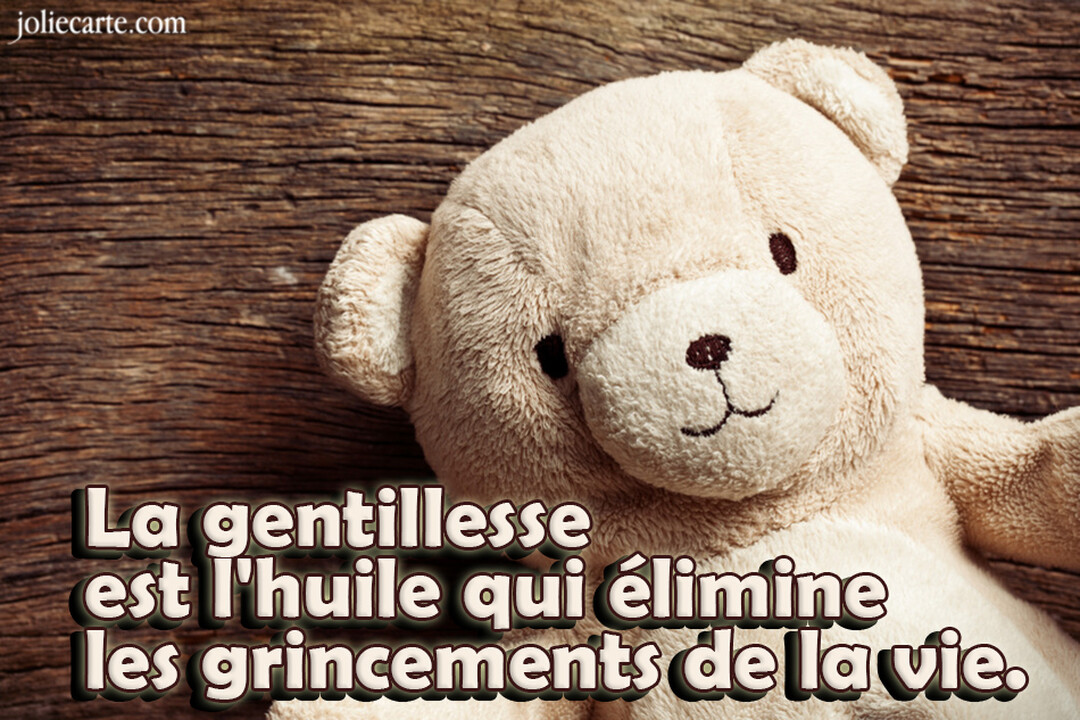 Un ours en peluche beige, au sourire doux, est allongé sur une surface en bois sombre et texturé, regardant vers le spectateur.
