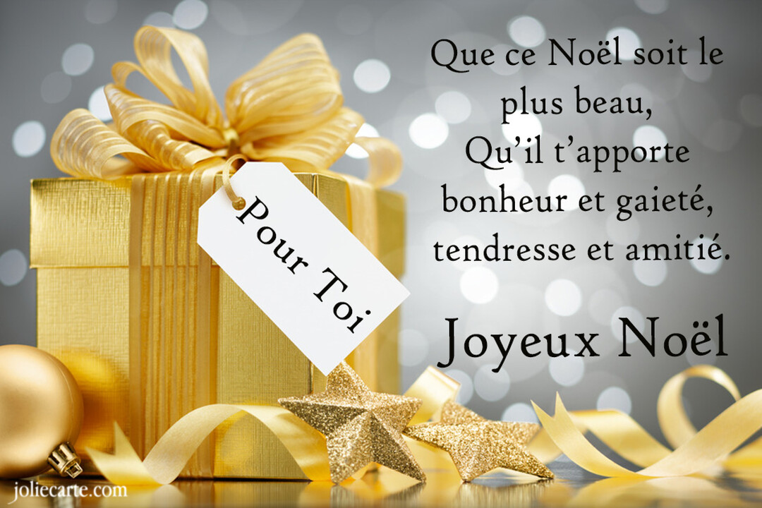 Un cadeau de Noël doré avec un grand ruban et une étiquette "Pour Toi" est posé près d'ornements scintillants sur fond gris.