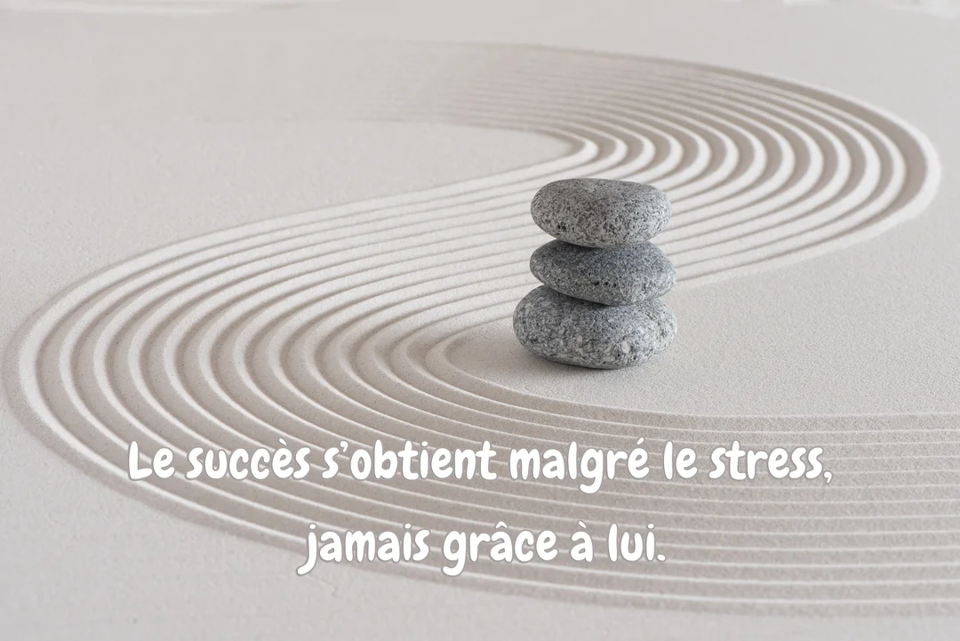 Trois galets gris sont empilés en équilibre sur du sable beige finement ratissé en courbes harmonieuses, évoquant un jardin zen apaisant.