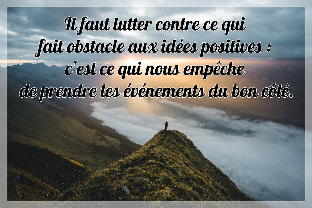 Une silhouette se tient au sommet d'une montagne verdoyante, face à un paysage de vallées couvertes de nuages sous un ciel lumineux.