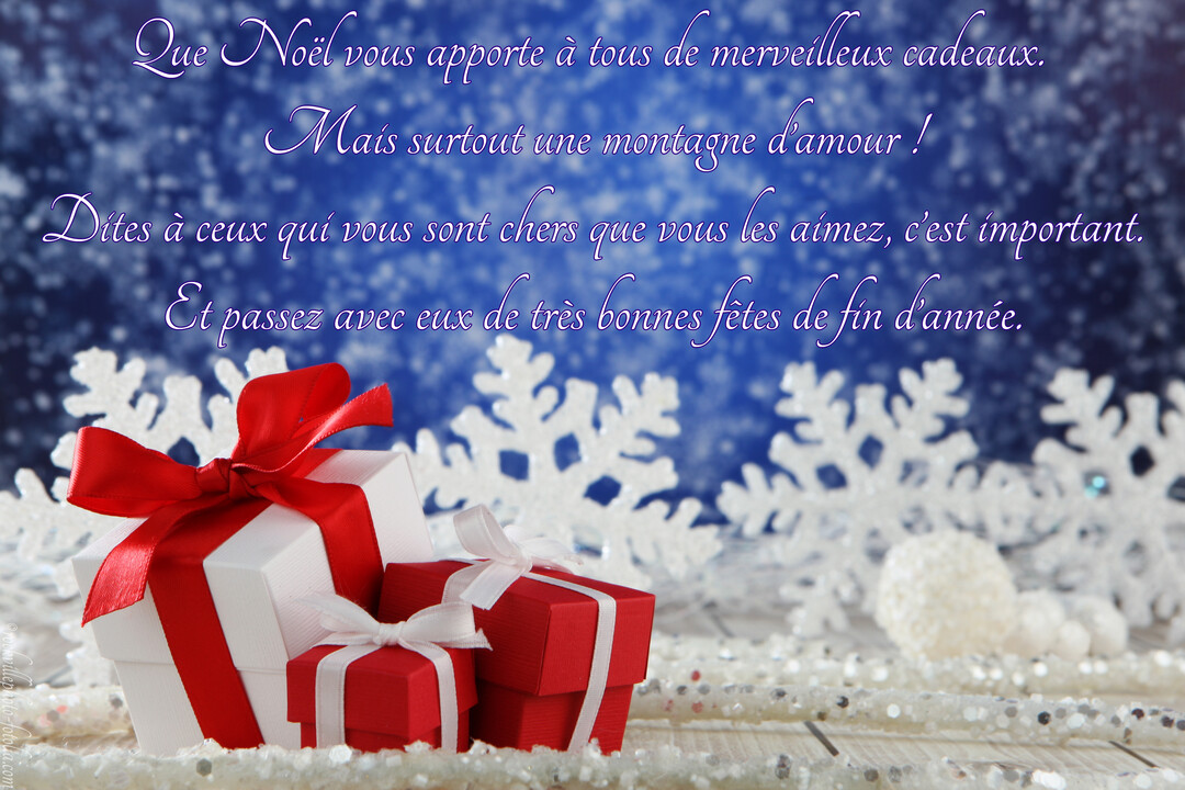 Des boîtes cadeaux rouges et blanches avec des rubans sont posées devant des flocons de neige décoratifs sur un fond bleu scintillant.