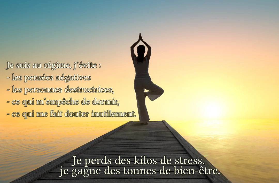 Silhouette d'une femme en posture de yoga sur un ponton en bois, se découpant sur un ciel coloré au lever du soleil.