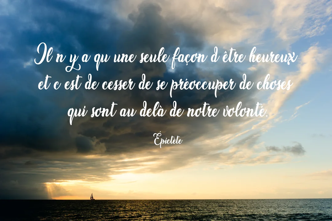 Un voilier navigue sur une mer calme au coucher du soleil, sous un ciel chargé de nuages sombres et de lumière dorée.
