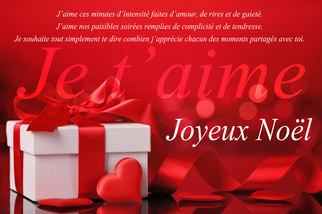 Une boîte cadeau blanche nouée d'un ruban de satin rouge se reflète sur une surface, avec un petit cœur posé devant.