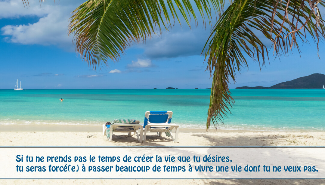 Deux transats sur une plage de sable blanc font face à une mer turquoise, sous des feuilles de palmier et un ciel bleu.