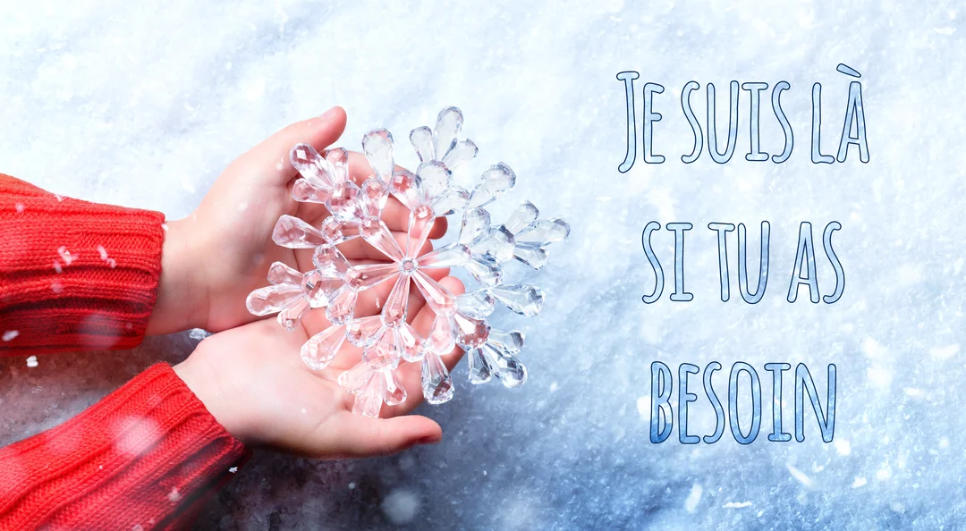 Des mains d'enfant portant un pull rouge tiennent délicatement un grand flocon de neige en cristal étincelant sur un fond blanc neigeux.