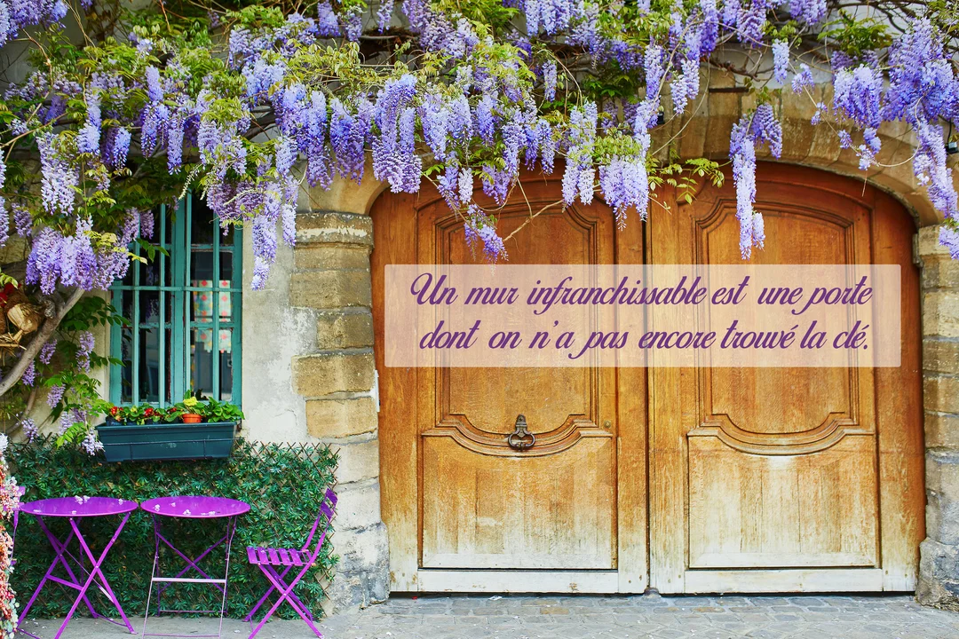 Une scène pittoresque montrant une porte en bois sous des cascades de glycine violette, avec une citation inspirante sur la persévérance superposée.