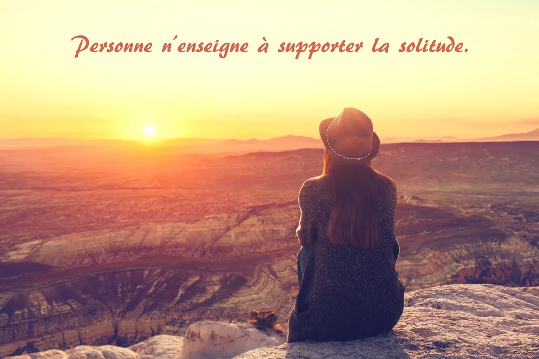 Vue de dos d'une personne assise au bord d'une falaise, regardant un vaste canyon baigné par la lumière dorée d'un soleil couchant.