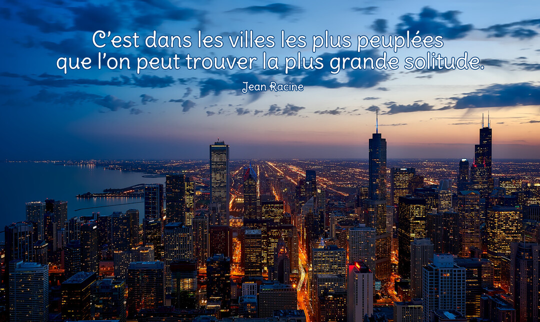Une photographie nocturne en plongée d'une métropole illuminée au bord de l'eau, sous un ciel crépusculaire avec quelques nuages.