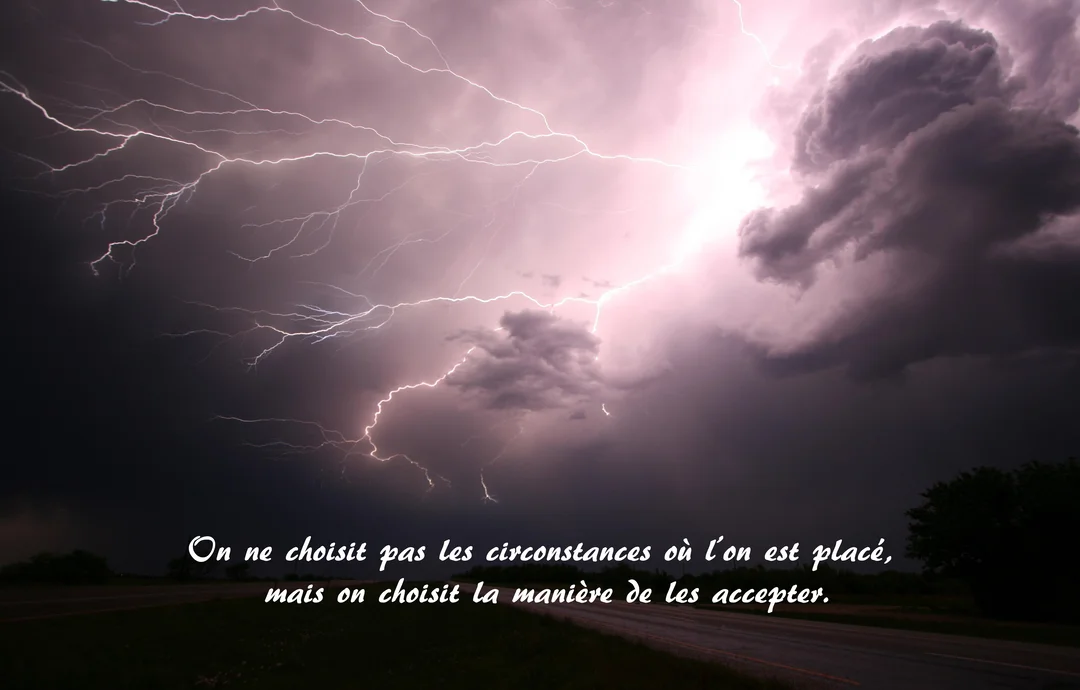 Un ciel nocturne orageux, rempli de nuages sombres, est illuminé par de multiples éclairs blancs et violets au-dessus d'un paysage sombre.