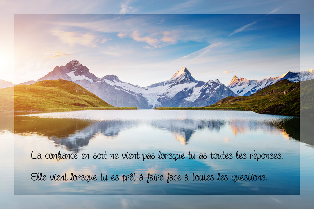 Un paysage majestueux de montagnes enneigées se reflétant dans un lac paisible, avec un ciel clair au lever ou au coucher du soleil.