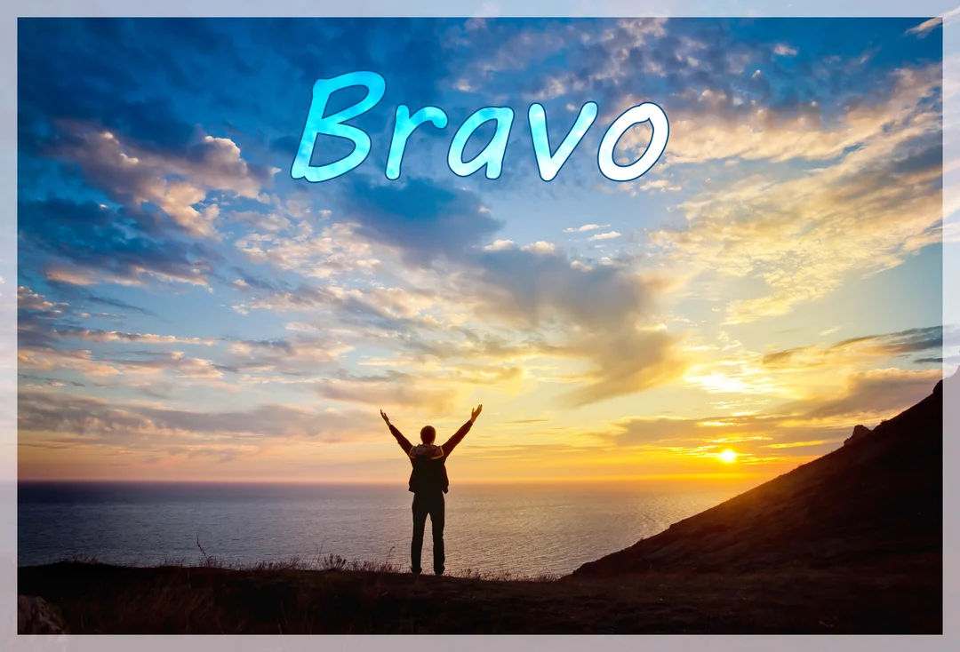 Une silhouette humaine se tient sur une colline, les bras levés en triomphe face à un spectaculaire coucher de soleil sur l'océan.