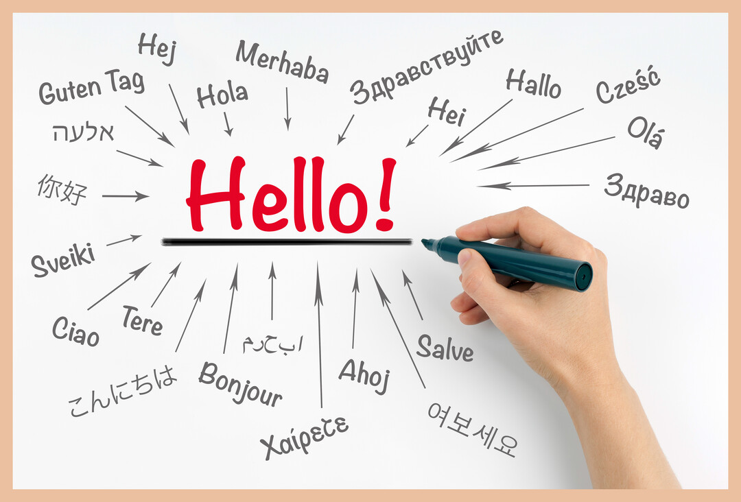 Sur un fond blanc, le mot 'Hello!' en rouge est entouré de ses traductions multilingues, avec une main à droite tenant un marqueur.