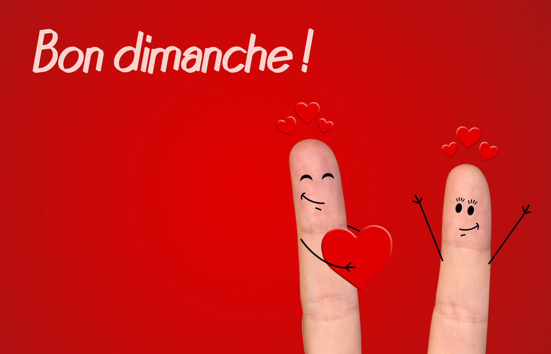 Deux doigts avec des visages souriants dessinés, l'un offrant un cœur à l'autre, sur un fond rouge vif avec l'inscription blanche 'Bon dimanche'.