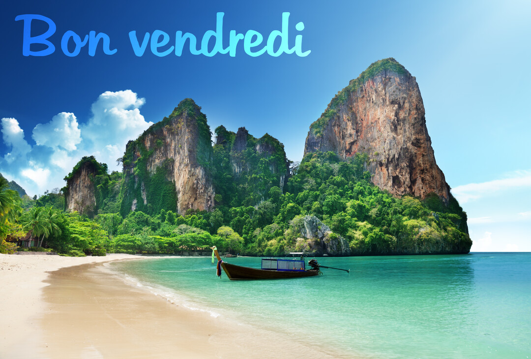 Paysage d'une plage tropicale avec du sable fin, une eau turquoise, un bateau traditionnel et d'impressionnantes falaises calcaires sous un ciel bleu.