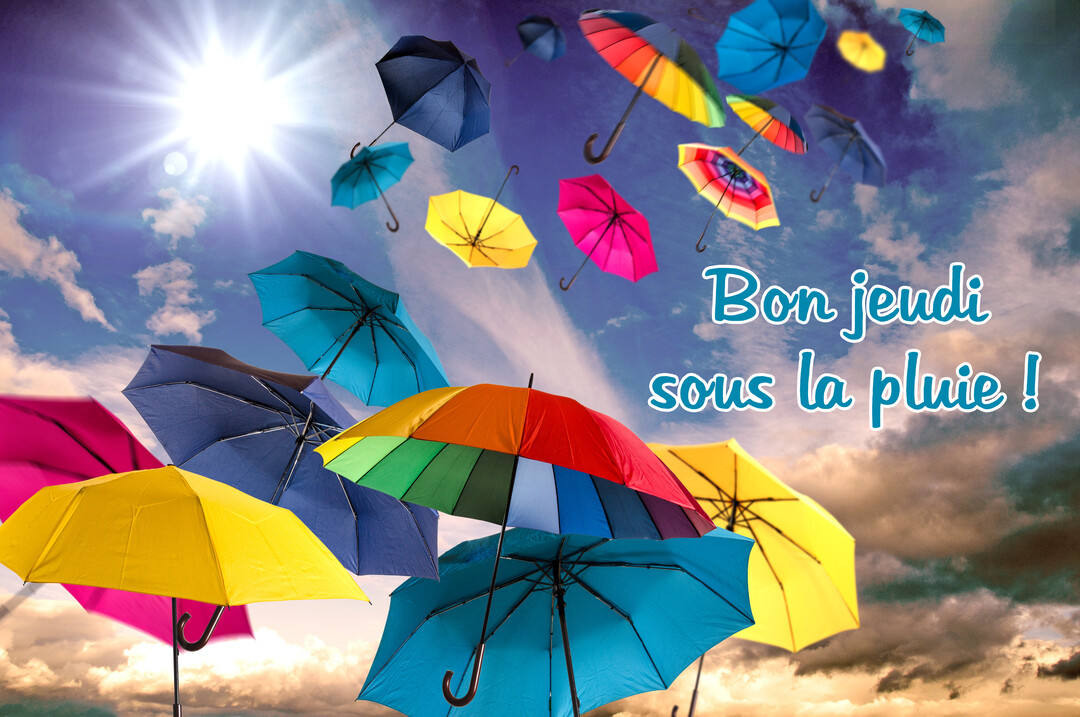 Des dizaines de parapluies multicolores s'envolent dans un ciel contrasté, à la fois nuageux et percé d'un soleil éclatant.
