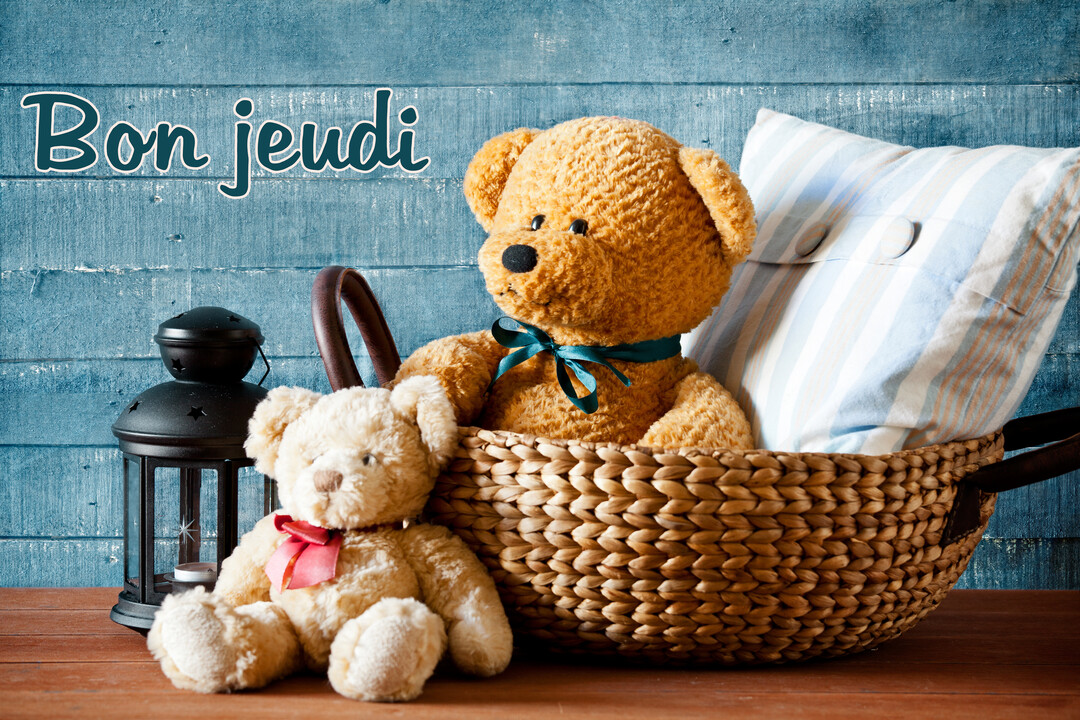 Deux ours en peluche sont mis en scène sur une surface en bois, avec un panier, un coussin et une lanterne sur un fond bleu.