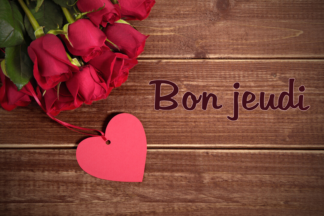 Un bouquet de roses rouges et une étiquette en forme de cœur sont posés sur des planches de bois, avec l'inscription "Bon jeudi".
