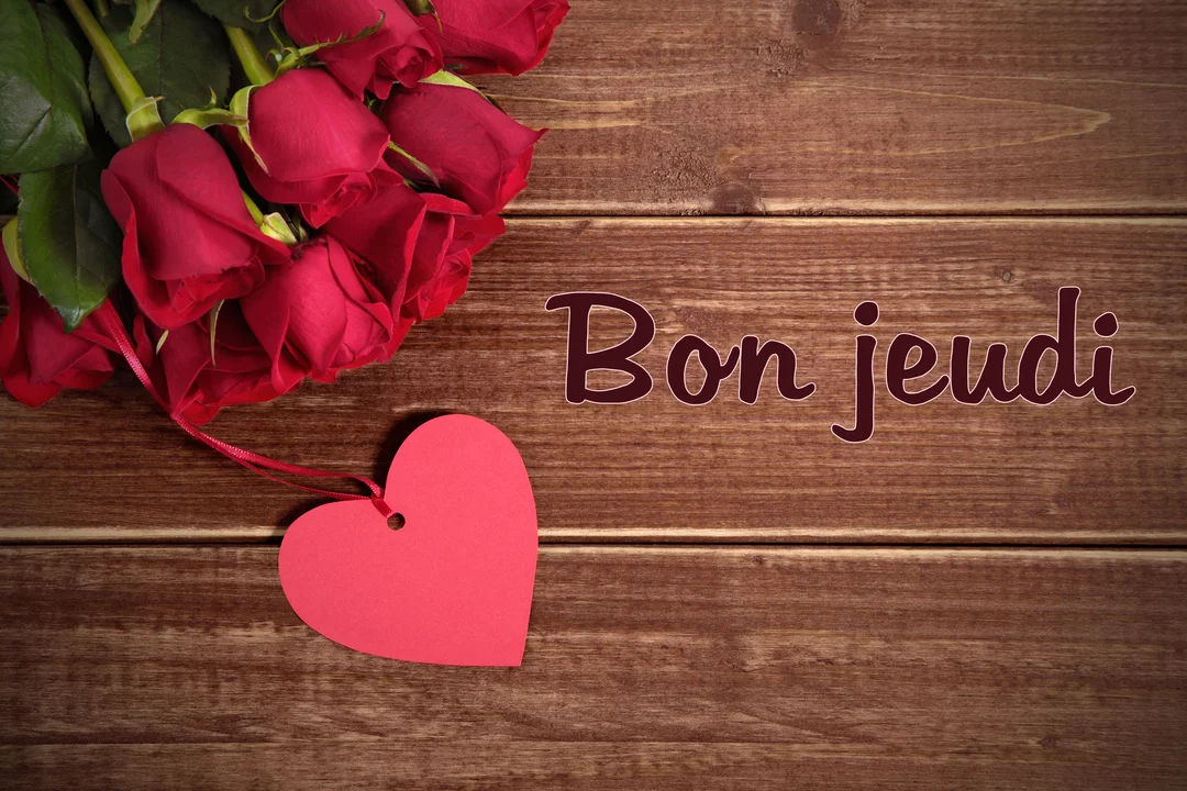 Un bouquet de roses rouges et une étiquette en forme de cœur sont posés sur des planches de bois, avec l'inscription "Bon jeudi".