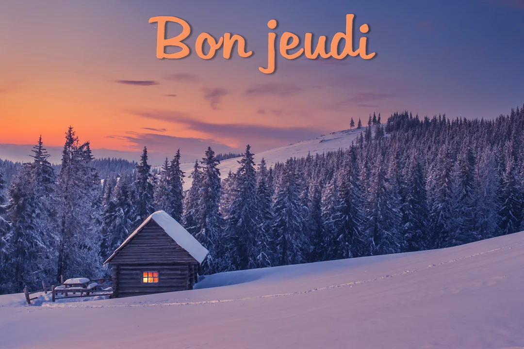 Un petit chalet en bois avec une fenêtre allumée est niché dans un paysage de montagne enneigé sous un ciel de crépuscule orangé.