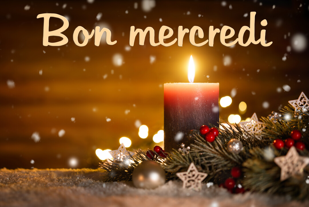 Une bougie rouge allumée est posée sur de la neige, entourée de branches de sapin, d'étoiles et de guirlandes lumineuses en bokeh.