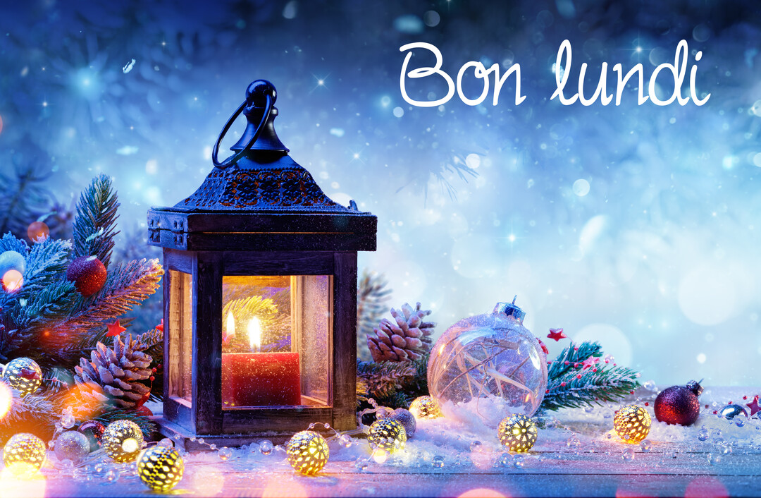 Une scène nocturne hivernale avec une lanterne éclairée, des boules de Noël et des branches de sapin reposant sur une surface enneigée.