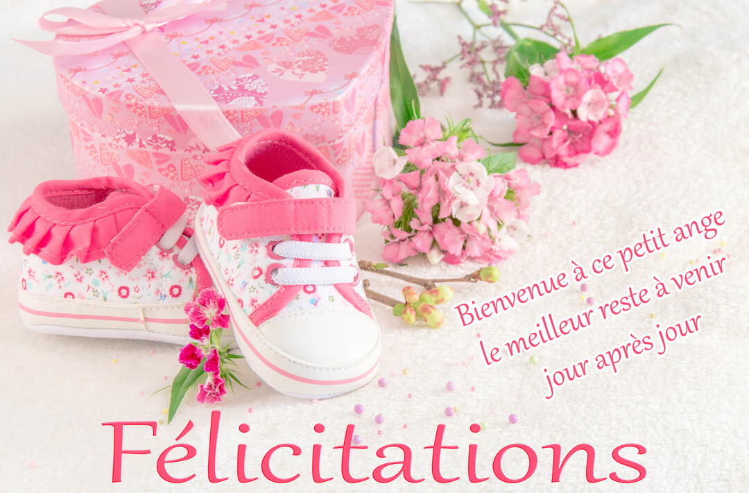 Une composition pour une naissance de fille avec des chaussons de bébé, une boîte cadeau rose et des fleurs sur un fond blanc.