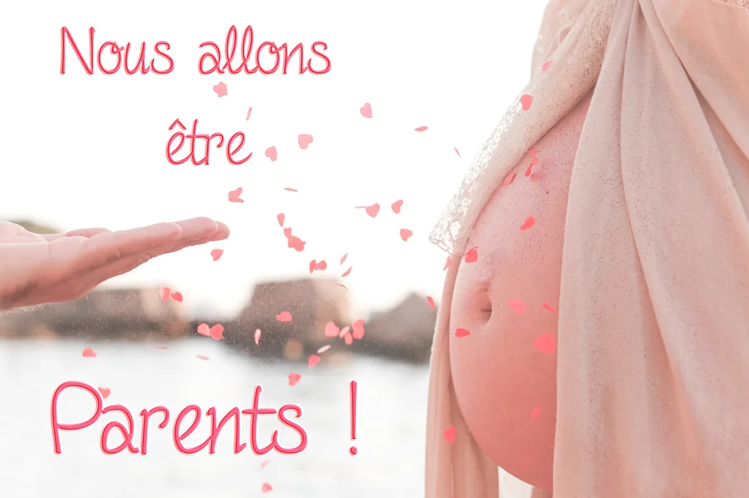 Gros plan sur un ventre de femme enceinte à côté d'une main, avec des confettis en forme de cœur tombant entre les deux.