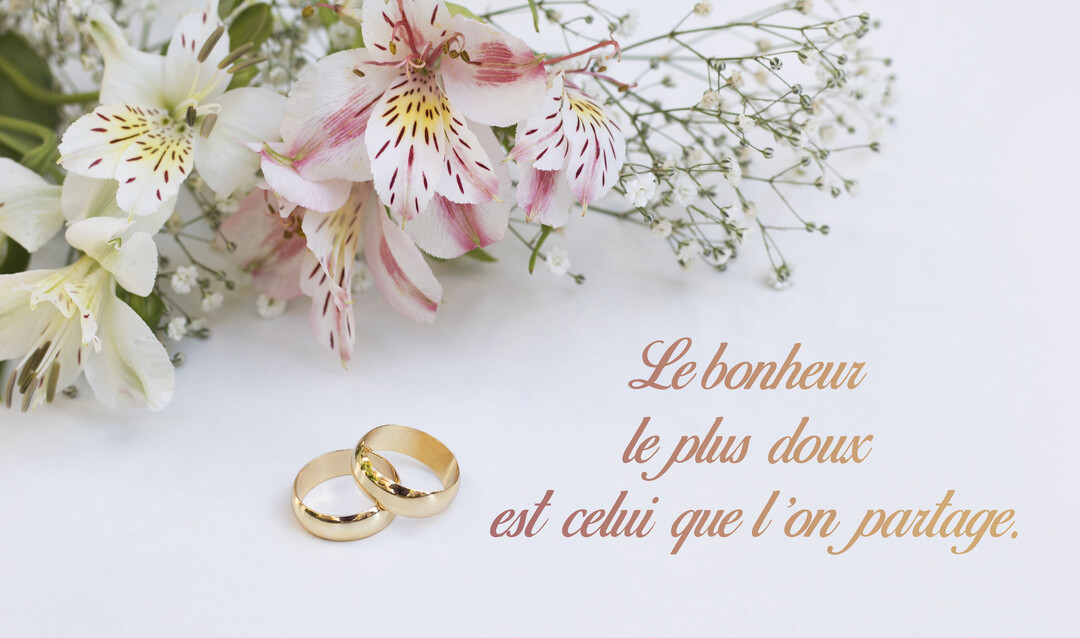 Sur un fond blanc, deux alliances dorées reposent à côté d'un bouquet d'alstroemerias et de gypsophiles, avec une citation sur le bonheur.