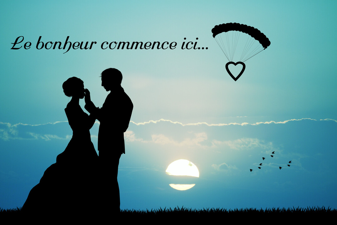 Silhouette d'un couple de mariés se tenant face à face au crépuscule, avec un parachute en forme de cœur dans le ciel.