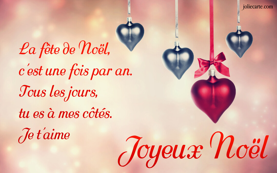 Plusieurs décorations de Noël en forme de cœur, une rouge et les autres argentées, pendent devant un fond lumineux et flouté.