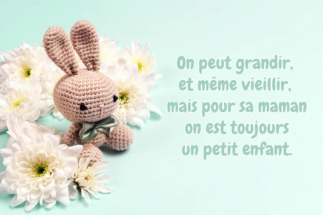 Photographie d'un lapin en crochet fait main, posé au milieu de chrysanthèmes blancs sur un fond pastel, illustrant une citation sur l'amour maternel.