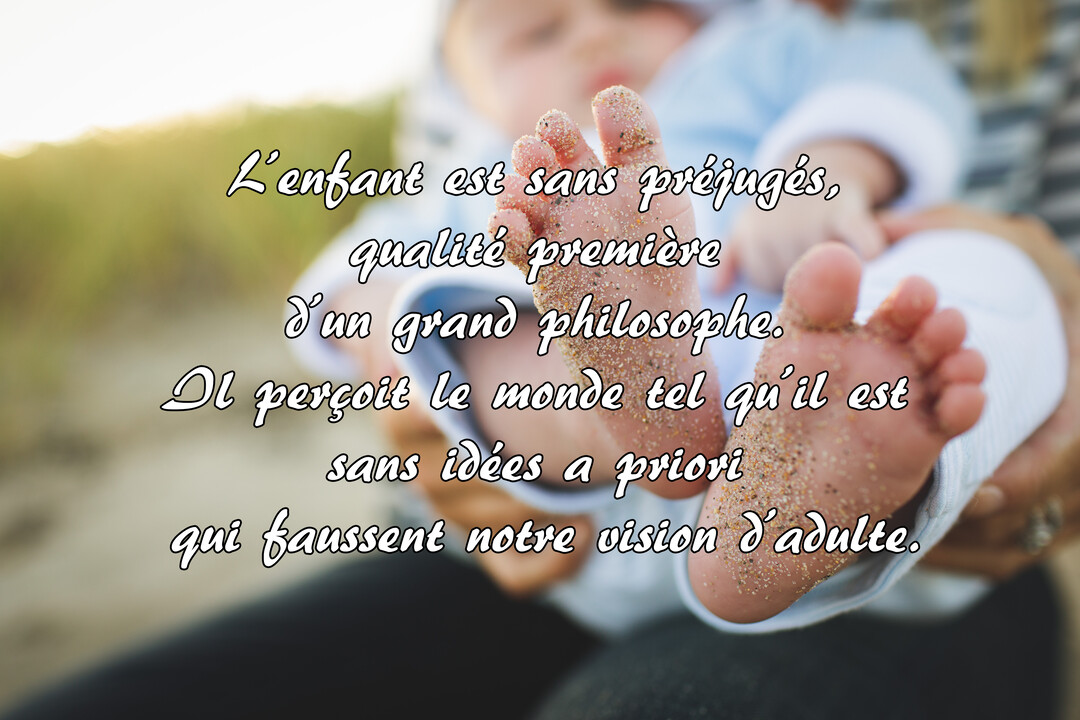 Gros plan sur les pieds d'un bébé couverts de sable fin, délicatement tenus dans les mains d'un parent, sur un fond flou.