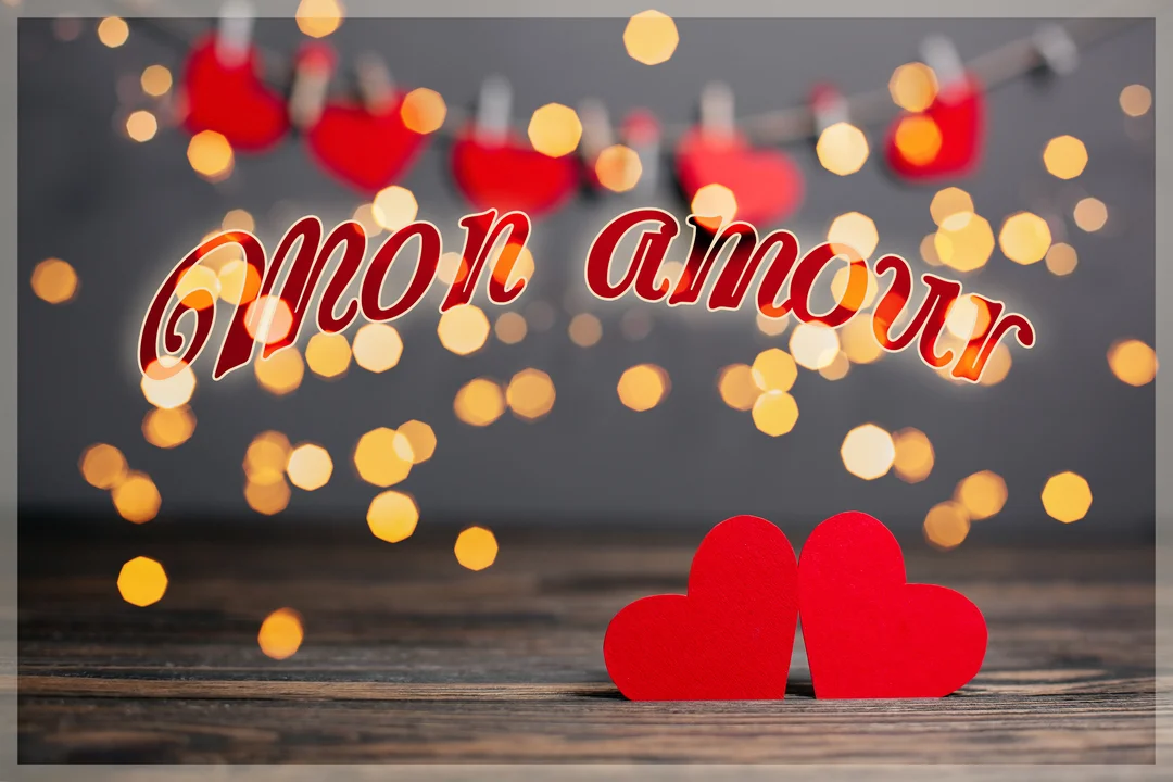 Deux cœurs rouges reposent sur une surface en bois, avec des lumières dorées diffuses et une guirlande de cœurs en arrière-plan flou.