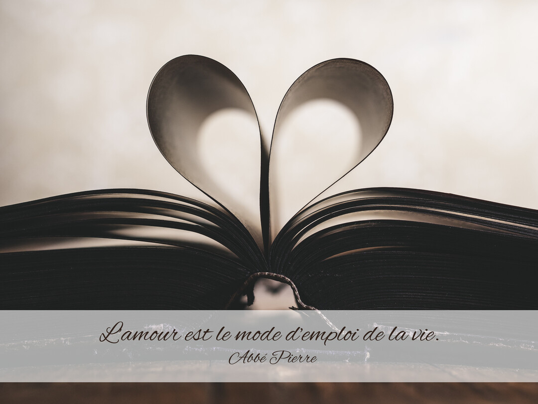 Photographie en tons sépia d'un livre ouvert dont les pages centrales sont pliées pour créer la forme d'un cœur parfait.