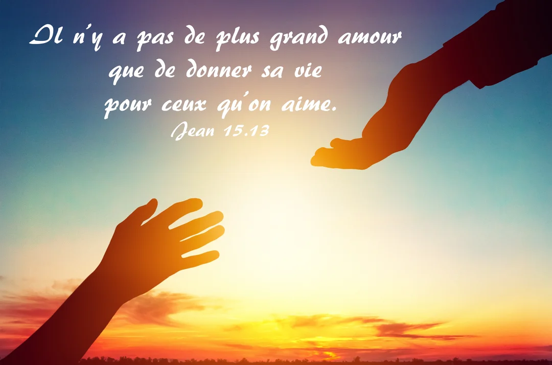 Deux mains en silhouette se rejoignent devant un ciel dégradé de bleu à orange, illustrant une citation sur l'amour et le sacrifice.