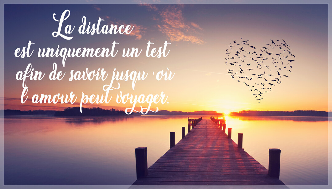 Un ponton en bois s'avance sur un lac calme au crépuscule, sous un ciel où des oiseaux en vol dessinent un grand cœur.