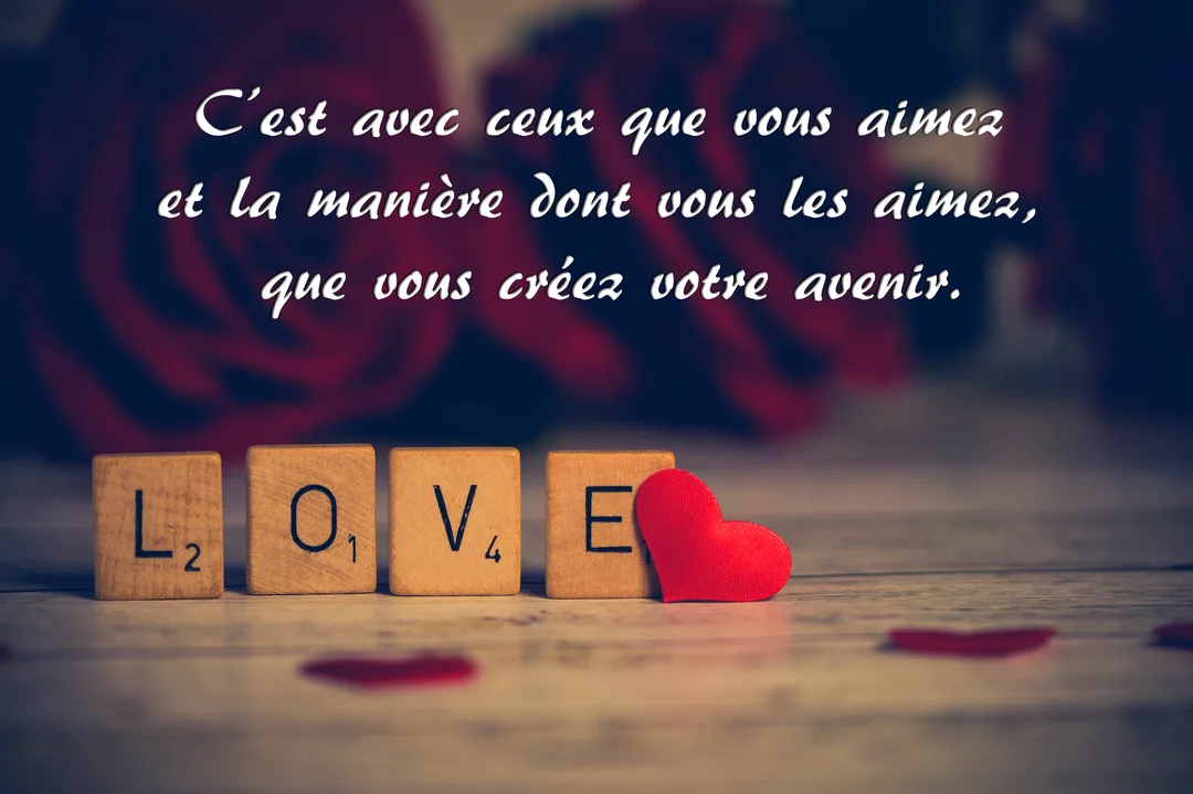 Au premier plan, des lettres de Scrabble épellent 'LOVE' près d'un cœur rouge, avec des roses et une citation romantique en arrière-plan.