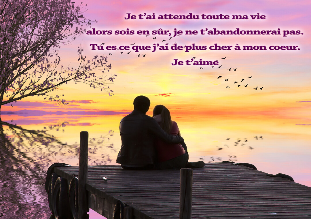 Un couple, vu de dos, est assis et enlacé au bout d'un ponton, contemplant un coucher de soleil coloré se reflétant sur l'eau.