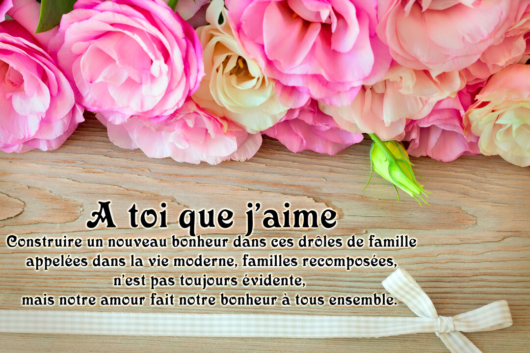 Une composition florale de lisianthus roses et blancs borde le haut d'une surface en bois, sur laquelle un message d'amour pour une famille recomposée est écrit.