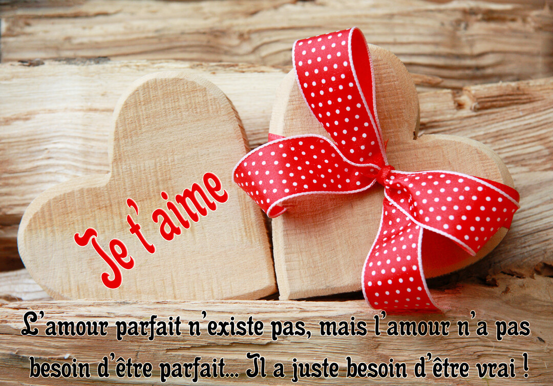 Deux cœurs en bois clair reposent sur des bûches, l'un avec le texte 'Je t'aime' et l'autre noué d'un ruban rouge à pois.
